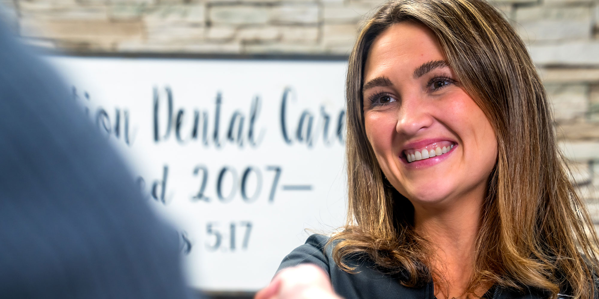 Team member greeting Patient into dental office